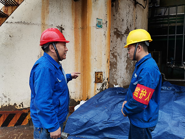 3月31日上午，在一期鍋爐舊脫硫塔底部清理現(xiàn)場，安全員焦路秦對監(jiān)護人岳維哲的提問。.jpg