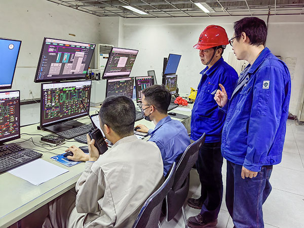 5月13日，動(dòng)力車間三期鍋爐控制室，DCS改造工藝、儀表、電氣等部門聯(lián)合調(diào)試，車間主任姜軍虎與技術(shù)員畢加佳查看調(diào)試過(guò)程.jpg