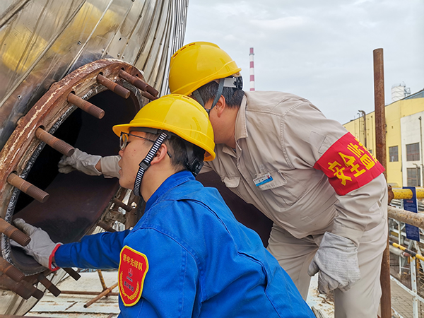 10月17日下午，在52工段除氧器人孔外，屈煒正在給董宇斌講述內(nèi)部構(gòu)造及工作原理。.jpg